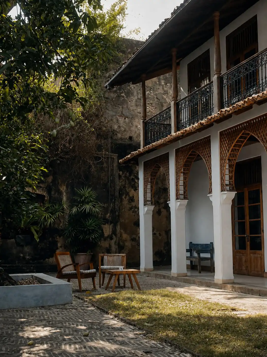 The walled courtyard at Kāffi Galle Fort, timber arches around zigzag brick with a tree in the middle.