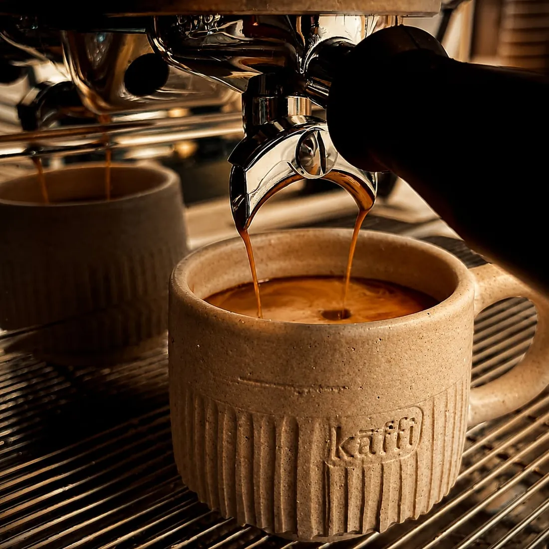 Espresso extracting into a ribbed cream stoneware cup stamped kaffi.